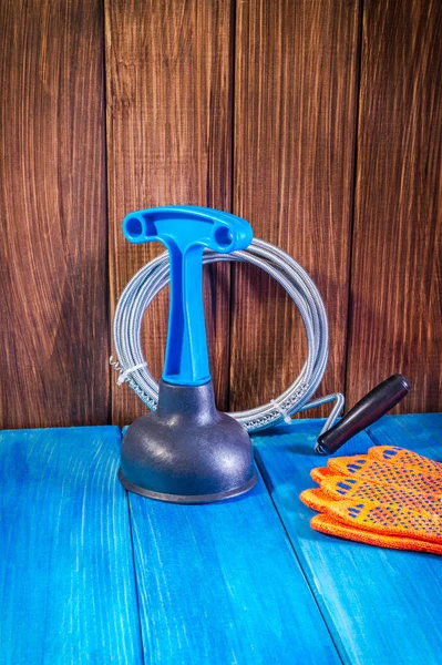 Clean plastic plunger with blue handle and cable on vintage wooden background — Stock Photo, Image