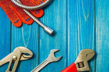 Mavi ahşap arka plan üzerinde tesisatçılar için gerekli araçlar seti.