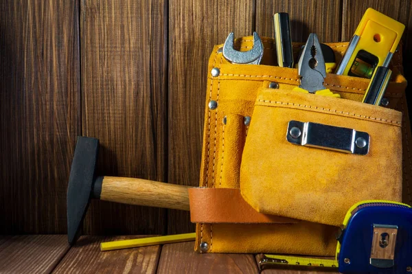 Herramientas e instrumentos en bolsa de cuero aislada sobre fondo de madera . — Foto de Stock