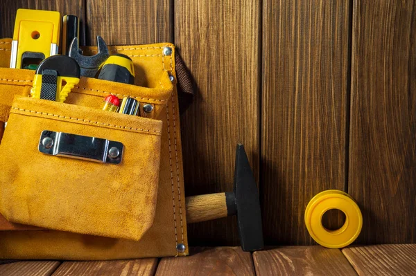 Herramientas e instrumentos en bolsa de cuero sobre fondo de madera . — Foto de Stock