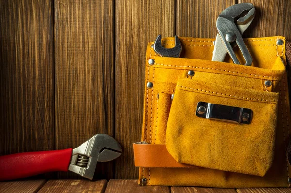 Herramientas e instrumentos en bolsa de cuero sobre fondo de madera . — Foto de Stock