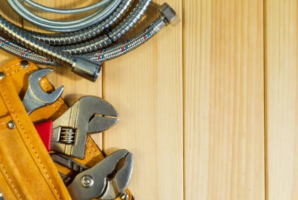 Potřebný soubor nástrojů ve vaku pro instalatéry na dřevěné pozadí. — Stock fotografie
