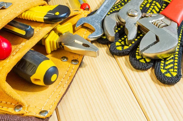 Noodzakelijke set van tools in de zak voor loodgieters op een houten achtergrond. — Stockfoto