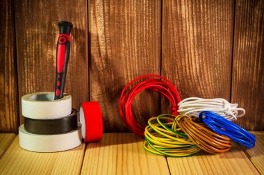 Ahşap arka planda elektrikçi için profesyonel alet ve aksesuarlar.
