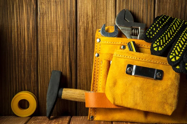 Herramientas e instrumentos en bolsa de cuero aislada sobre fondo de madera . — Foto de Stock