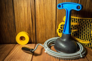 Mavi saplı temiz plastik pompa, tahta arka planda boru anahtarı ve kablo..