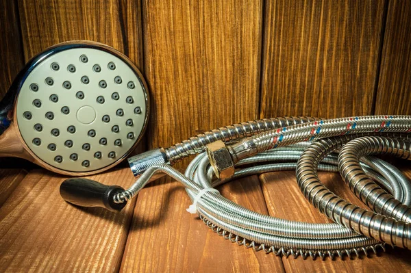 Shower head on vintage wooden background and other plumbing parts. — Stock Photo, Image