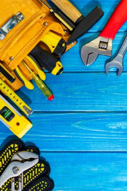 Eski mavi ahşap arka planda bir çantada gerekli araçlar seti.