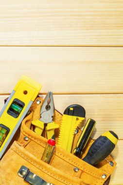 Doğal ahşap arka planda bir çantada gerekli araçlar seti.