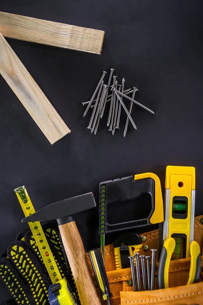 Herramientas en la bolsa para carpintería y accesorios sobre fondo negro . — Foto de Stock
