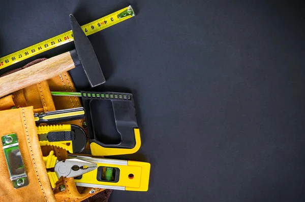 Herramientas en la bolsa para carpintería y accesorios sobre fondo negro . — Foto de Stock