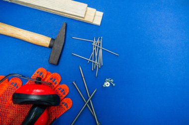 Doğrama ve yedek parça için profesyonel araçlar, mavi arka plan üzerinde kulaklıklar.