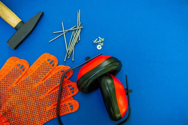 Professional tools for the joiner and spare parts, headphones on a blue background.