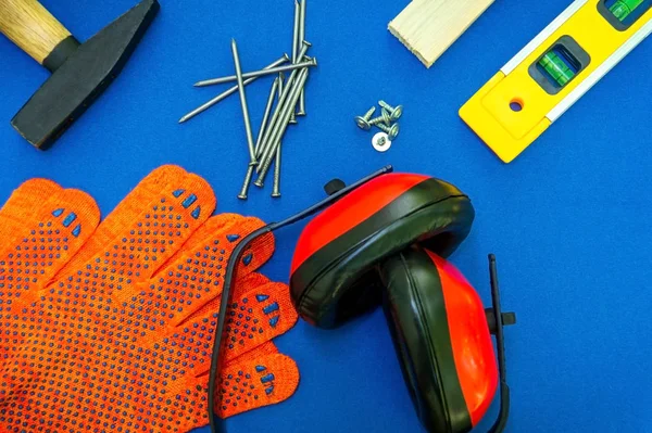 Professional tools for the joiner and spare parts, headphones on a blue background.