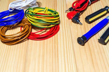 Ahşap tahtalarda elektrikçi için aletler ve yedek parçalar.