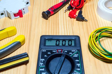 Ahşap tahtalarda elektrikçi için aletler ve yedek parçalar.