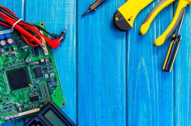 Ahşap mavi arka plan üzerinde elektronik ve onarım üretimi için hizmetler.