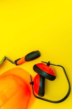 Sarı bir arka plan üzerinde oluşturucu için bir çanta içinde koruyucu ekipman ve araçlar.