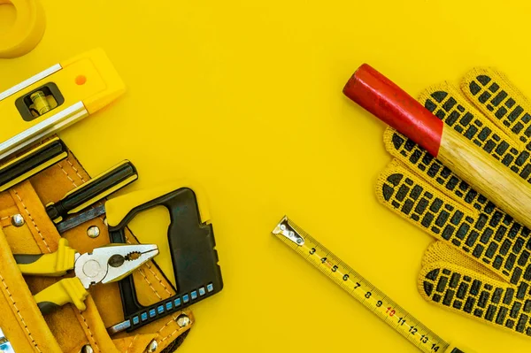 Herramientas profesionales para el maestro constructor sobre un fondo amarillo . — Foto de Stock