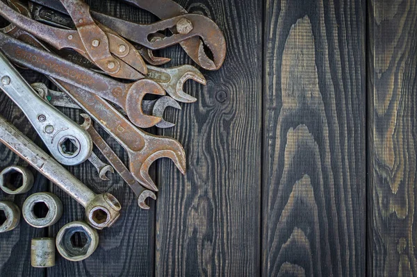 Rusty Old Tools on black vintage wood background.