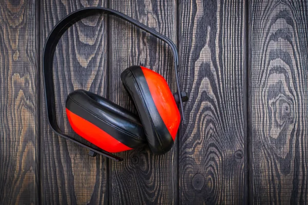 Protective headphones on dark wood background. Professional construction accessory