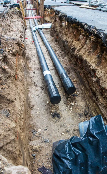 Dos tuberías de agua negra en zanja de pozo subterráneo durante la fontanería en construcción reparación — Foto de Stock