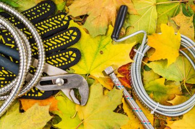 Tesisatçılar için sarı yapraklı arka planda gerekli aletler