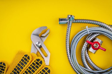 Su hortumlarını sarı zemine bağlamak için boru ve eldivenler