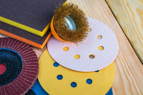 Set of abrasive tools and sandpaper different colors on vintage wooden background