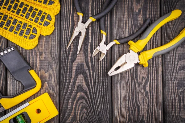 Herramientas para maestro constructor y accesorios sobre un fondo vintage negro de madera —  Fotos de Stock