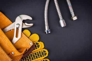 Su hortumlarını siyah arkaplana bağlamak için poşetteki tesisat araçları