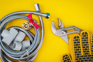 Su hortumlarını sarı zemine bağlamak için boru ve eldivenler