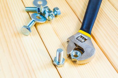 Ahşap zemin üzerinde metal cıvata ve ceviz ayarlanabilir ingiliz anahtarıyla