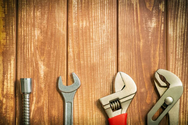 Eski ahşap tahtalardaki tesisatçılar için profesyonel bir alet ve hortum.