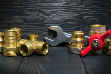 Tesisat veya gaz borularında kullanılan eski siyah tahtalar üzerindeki pirinç tesisatlar ve araçlar