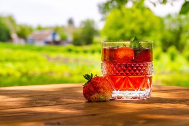 Masada çilek ve güneşli bir günde naneli taze içecek.