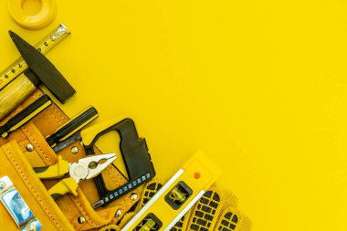 Katılımcı ve sarı arkaplanda yedek parçalar için profesyonel araçlar çantada