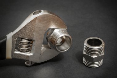 Yedek parçaların onarımı veya değiştirilmesi sırasında koyu arkaplandaki tesisat montajı ve ayarlanabilir anahtarlar