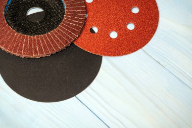 Ahşap mavi tahtalar üzerinde aşındırıcı aletler ve kahverengi zımpara kağıdı.