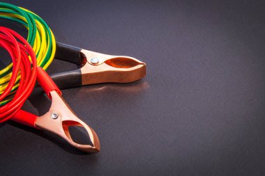 Çok renkli kablolar ve timsah klipleri siyah arka plandaki usta elektrikçi için hazırlandı