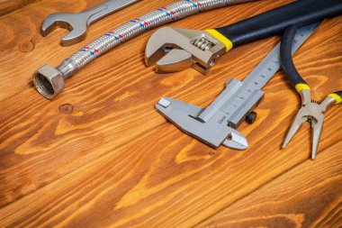 Tesisatçılar için gerekli alet ve hortum reklam için yeri olan eski ahşap tahtalar.