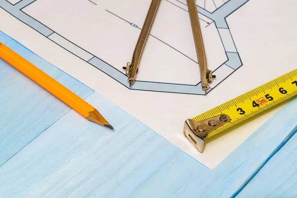 Diagramas de la casa y accesorios para el dibujo acostado en el dibujo de la construcción y una mesa de taller azul para trabajos de ingeniería de proyectos — Foto de Stock