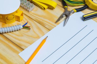 Tahtadaki yedek parça ve aletlerle elektrik teçhizatını onarmak için bir plan hazırlıyorum.
