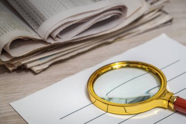 Antette gazete okumak için büyüteç. Planlama ve analiz sırasında ev ortamı