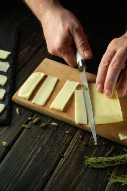 Aşçı bıçakla Mozzarella peynirini bir restoranın mutfağında aperatif sandviç hazırlamak için kesti. Öğle yemeği için lezzetli atıştırmalıklar.