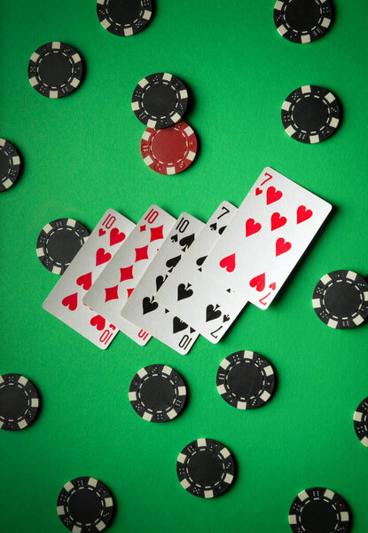 A vibrant composition of playing cards, consisting of a full house or full boat, surrounded by black and red poker chips. This composition conveys the excitement and thrill of a gaming evening.