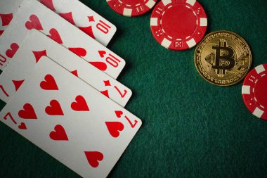 Yeşil kumaş, iki çift iskambil kağıdı, kumarhane fişi ve bir Bitcoin sembolünü betimliyor. Bu kompozisyon geleneksel ve modern unsurları birleştiren bir oyun akşamı için tipik bir özelliktir..