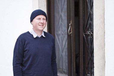 Beyaz Saray'a kopya alanı ile kahverengi ana kapının yanında duran bir adam