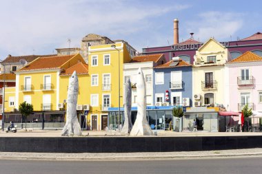 Sardines' roundabout with colorful houses behind in marina of Setubal, Portugal clipart