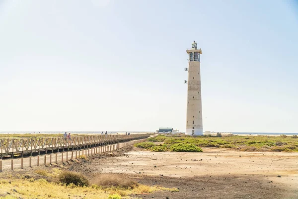 Lighthouse and wooden bridge with tourists in Morro Jable, Fuert